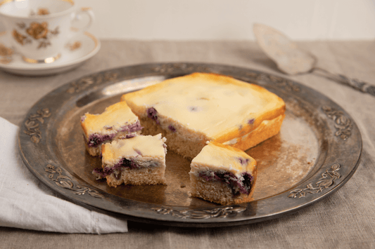 Mustikkarahkakakku – mehevä pohja, samettinen rahkatäyte ja raikkaat mustikat. Täydellinen herkku juhliin ja arjen kahvihetkiin.